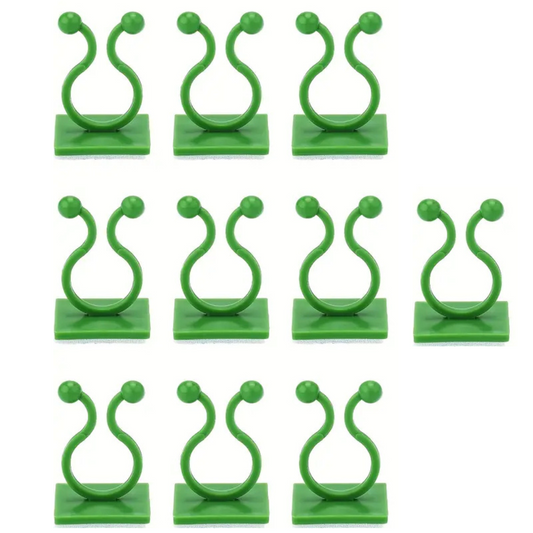 Plusieurs attaches murales vertes en plastique pour plantes grimpantes sont disposées en trois rangées sur un fond blanc.