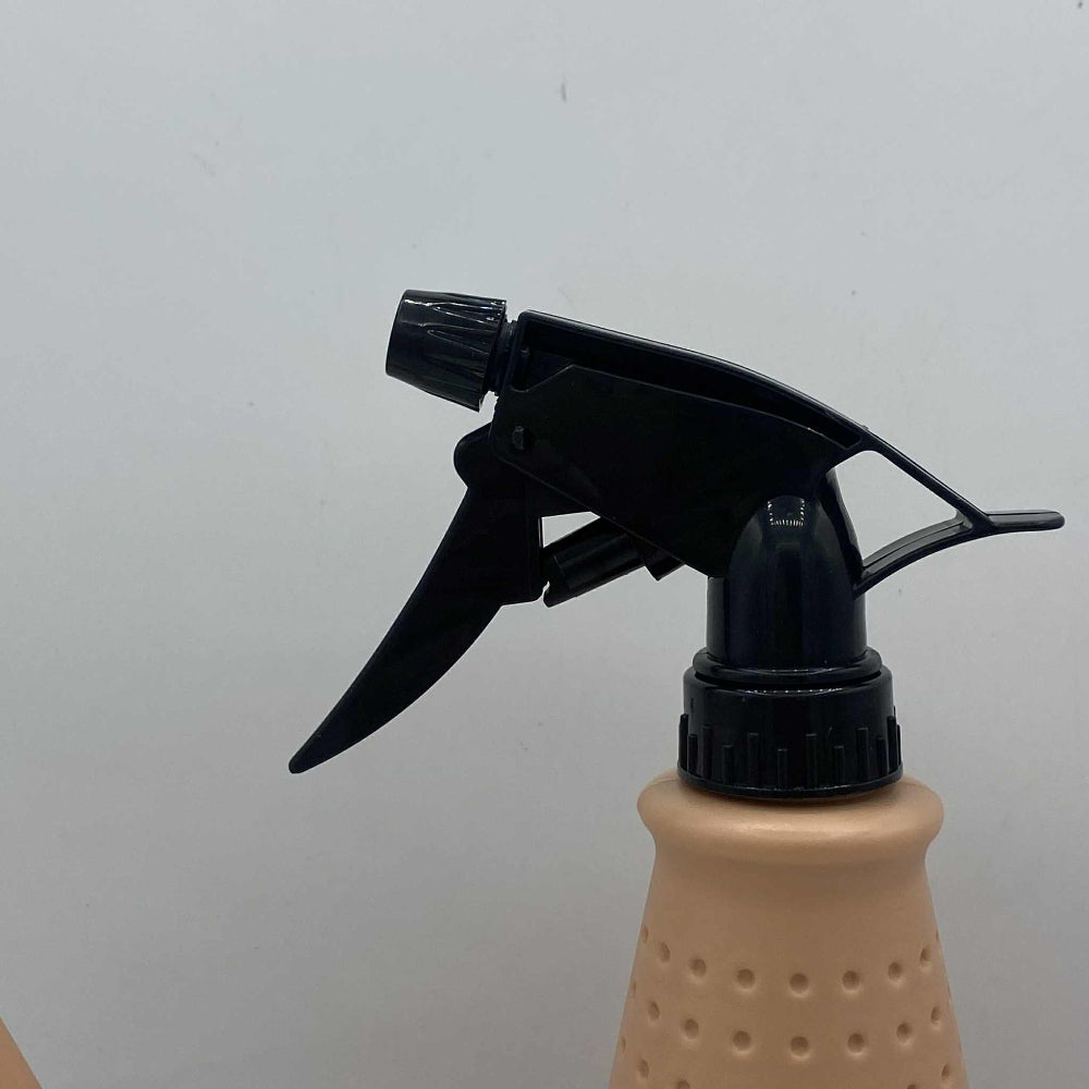 Gros plan sur le bec rectangulaire d'un arrosoir en plastique beige, montrant un arrosoir hybride.