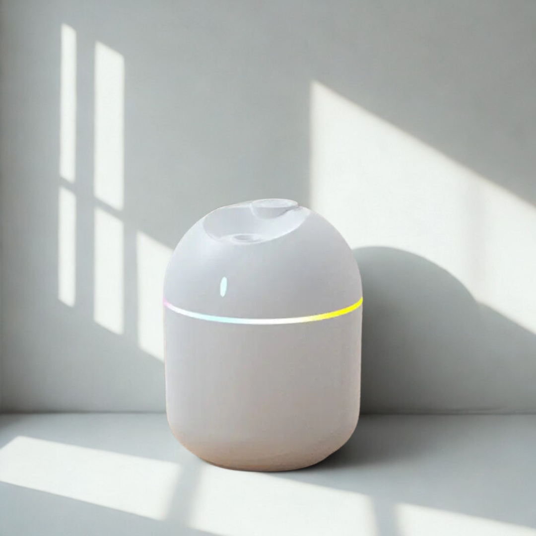 Un humidificateur pour plantes blanc et ovoïde, avec une bande lumineuse LED colorée et une fine brume qui s'échappe par le haut.