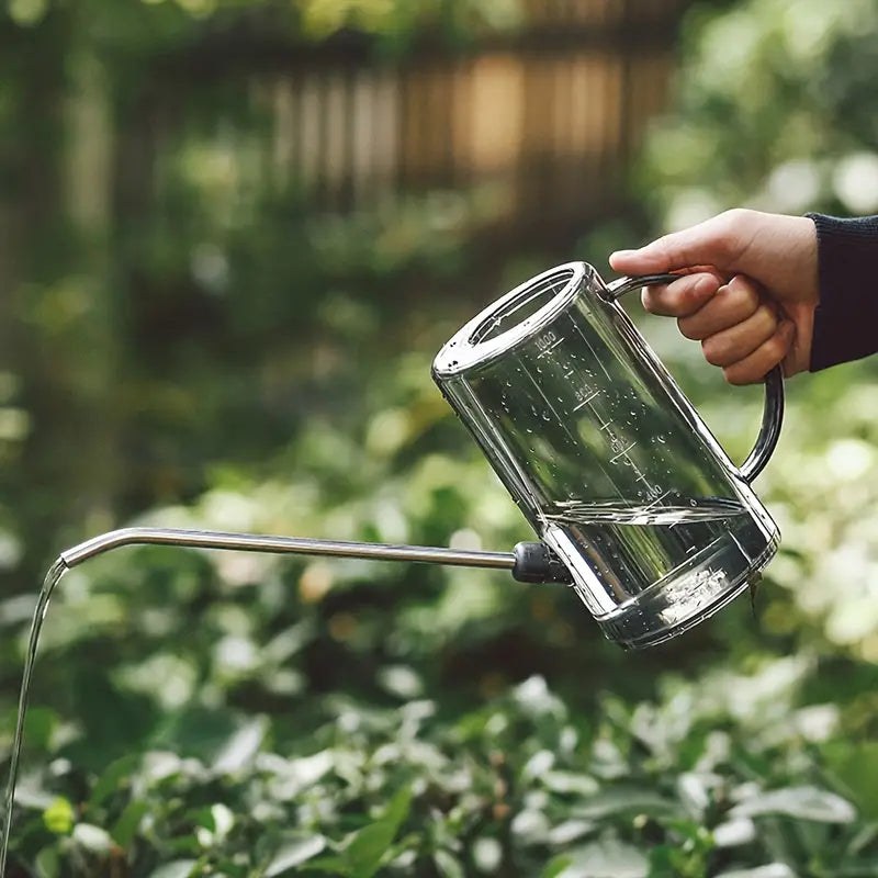 arrosoir transparent stylé avec un bec long utilisé pour arroser des plantes dans un jardin