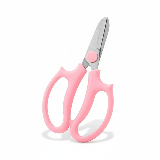 Cisaille de précision rose compacte, lames en acier inoxydable, sur fond blanc de studio.