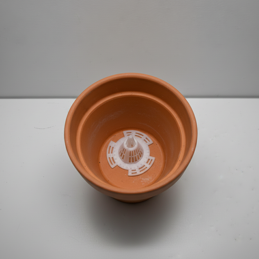 Système de drainage conique en place au fond d'un pot de fleurs en terre cuite, illustrant sa hauteur pour une meilleure aération.
