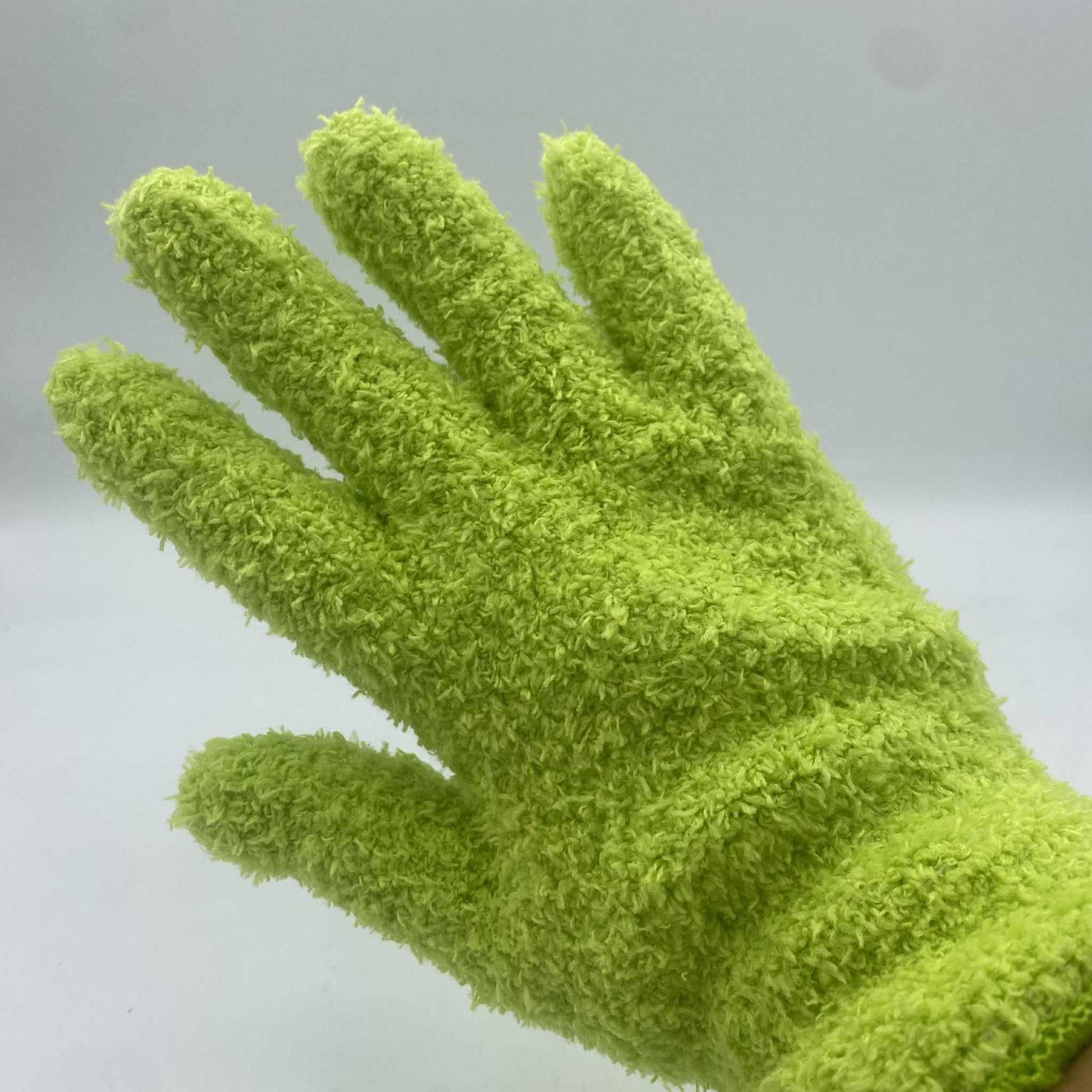 Gros plan sur un gant de nettoyage ou d'exfoliation en microfibre douce et duveteuse, de couleur vert vif