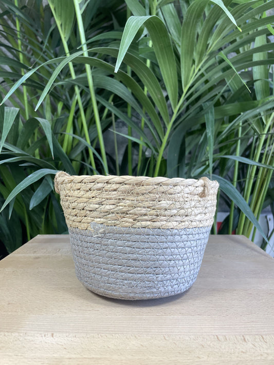 Panier décoratif en fibres naturelles avec un style tressé, en vue générale sur la base gris 