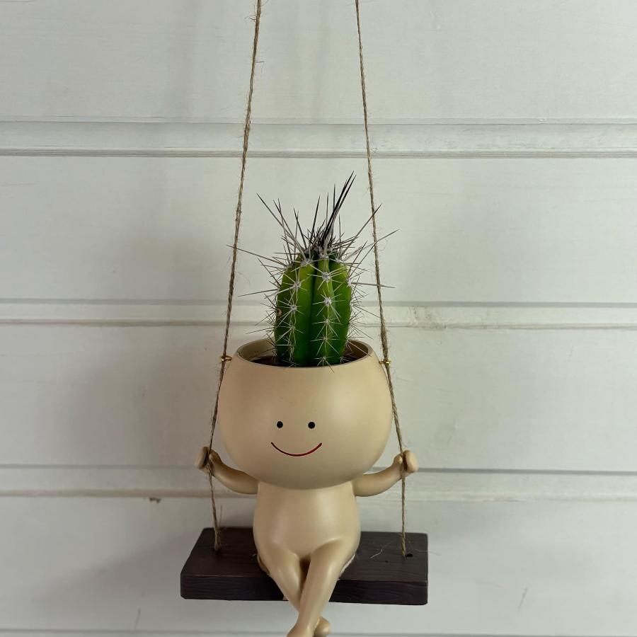 petit pot de plantes suspendu avec une tete formée par un cactus 