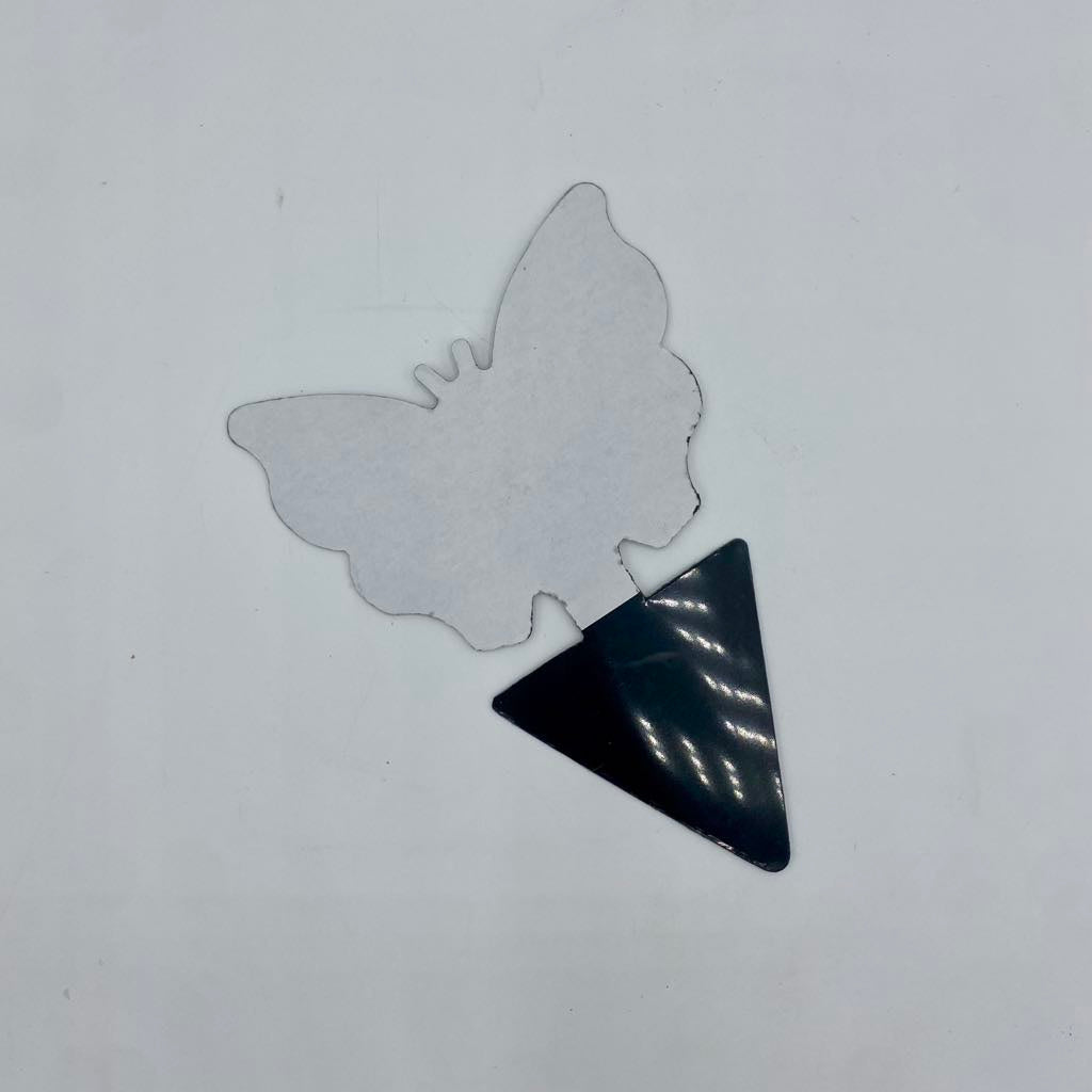  Feuille de recharge d'attrape-moucherons en forme de papillon avec une pointe noire triangulaire, vue sur un fond blanc.