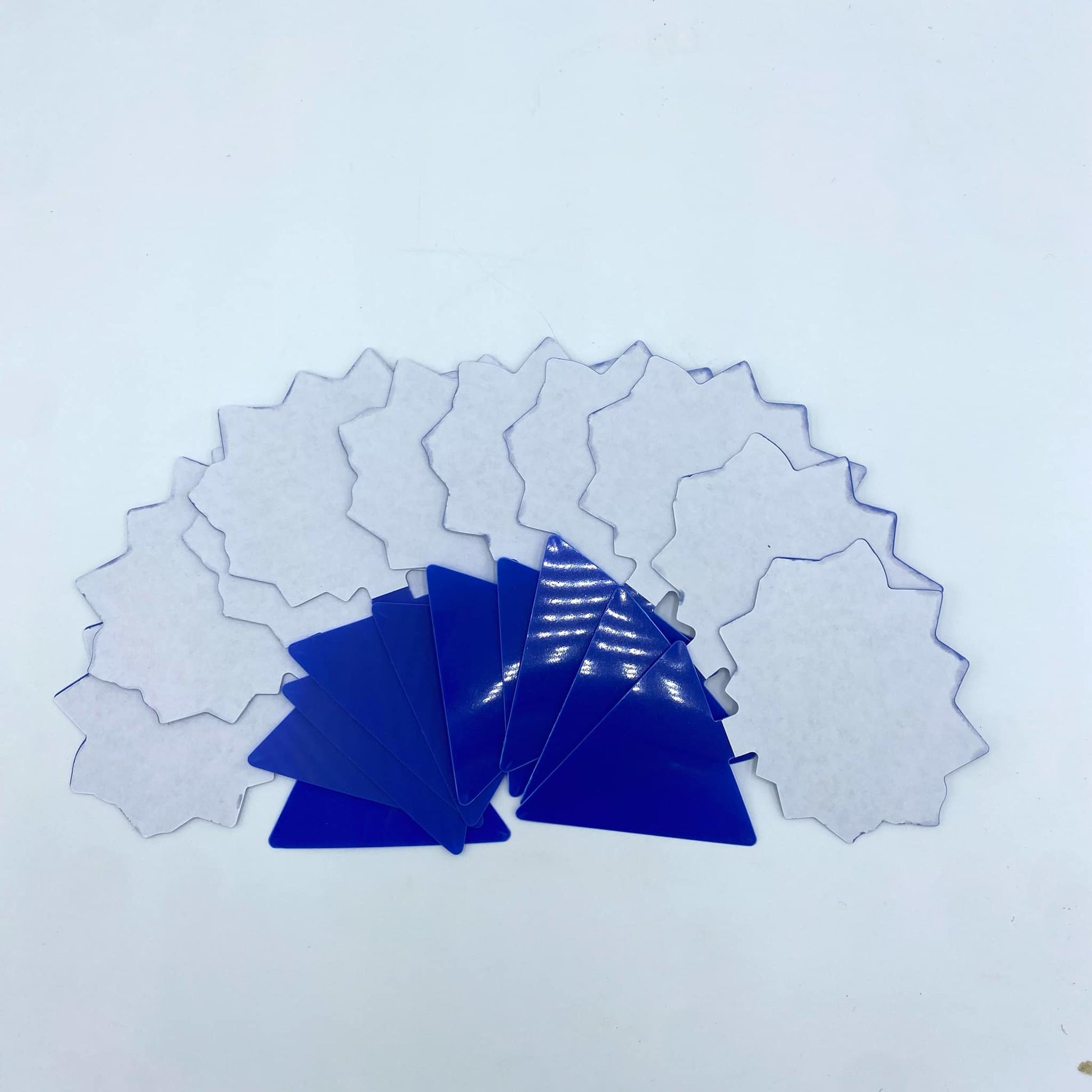 Une collection de pièges à insectes adhésifs en forme d'étoile de couleur bleue et blanche, disposés sur un fond blanc.
