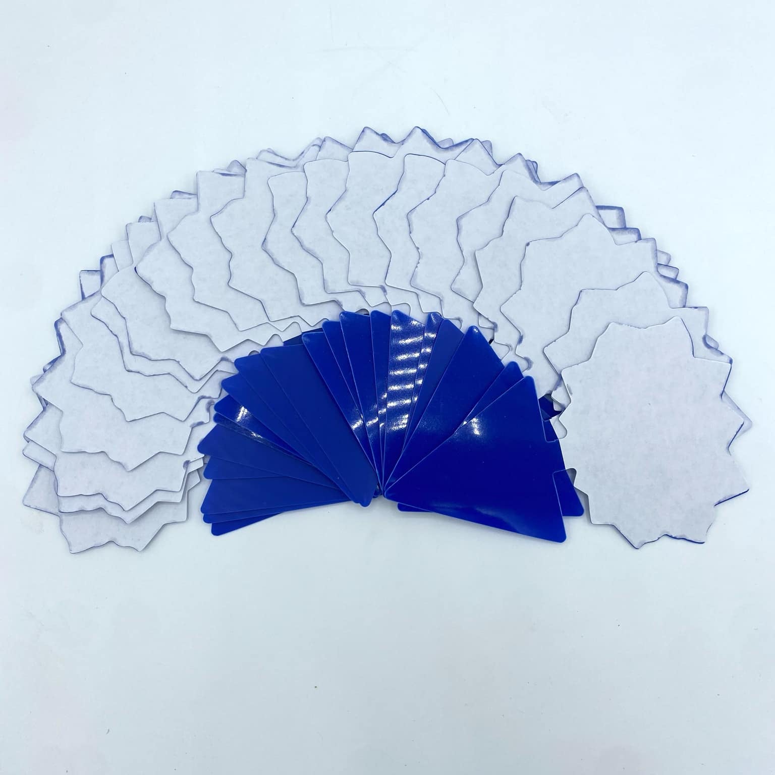 Une collection de 20 pièges à insectes adhésifs en forme d'étoile de couleur bleue et blanche, disposés sur un fond blanc.