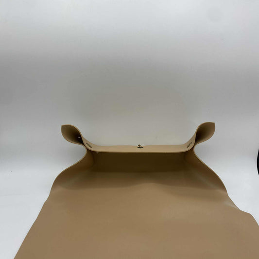  Un tapis de rempotage beige, avec les coins relevés par des boutons-pression pour former un plateau, sur un fond blanc.